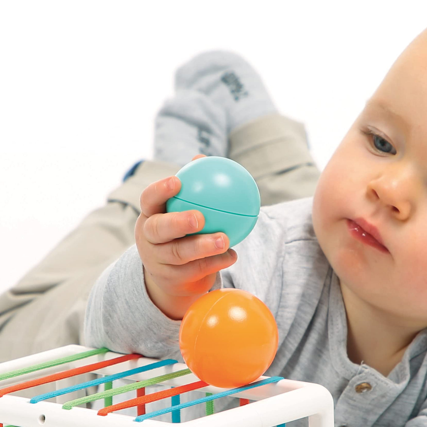 Ludi Babywürfel – Spielzeug für Babys – ab 10 Monaten – entwickelt Denken, Feinmotorik, Berührung und Entdeckung – 1 elastischer Würfel + 12 orangefarbene und Blaue Bälle mit lustigem Klang