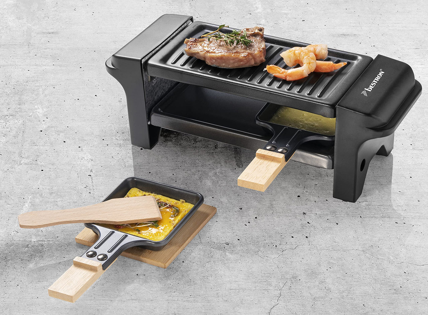 Bestron Raclette für 1 bis 2 Personen, Mini Tischgrill mit zwei Pfännchen, zwei Holzschabern & zwei Untersetzern, 350 Watt, Farbe: Schwarz