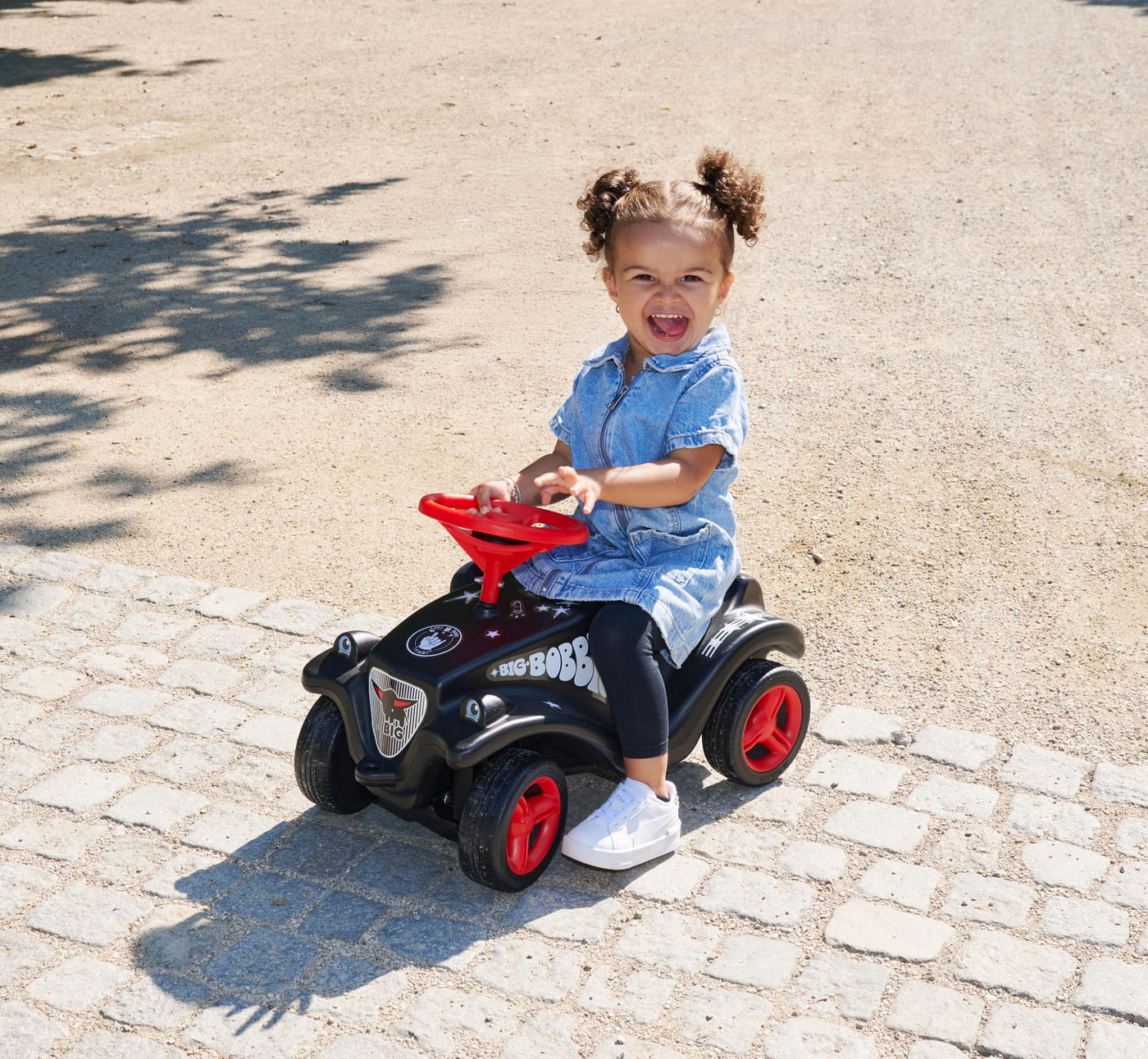 Big Bobby Car Classic Little Rocker - Rutschauto ab 1 Jahr im dunklen Rock n‘ Roll-Design mit rotem Sicherheits-Lenkrad und Hupe, für Kinder ab 12 Monaten (bis 50 kg), schwarz mit Aufklebern